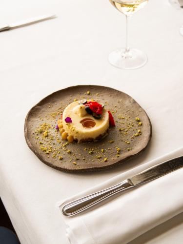 a plate with a dessert on a table with a glass at Hostal Empúries in L'Escala