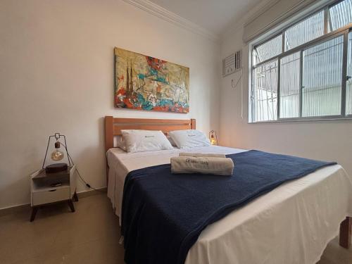 a bedroom with a bed with a blue blanket at Refúgio Aconchegante em Botafogo in Rio de Janeiro
