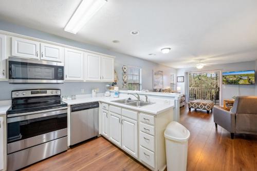 a kitchen with white cabinets and a stove top oven at 53C Tee to Sea condo in Pawleys Island