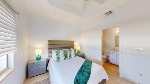 ein weißes Schlafzimmer mit einem Bett und einem Badezimmer in der Unterkunft South Bay Beach Club #37 Penthouse - 3 Bedroom 3 Bathroom Unit in George Town