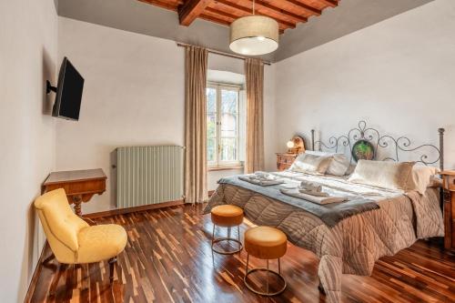 Un dormitorio con una cama grande y dos sillas. en Busdraghi Luxury Apartment, en Lucca