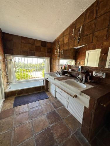 a large bathroom with a sink and a window at Villa Loupiro in Mijas