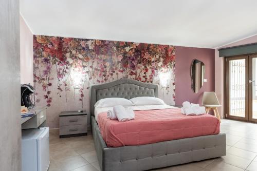 a bedroom with a bed with a floral wall at B&B Golden House & spa in Rose