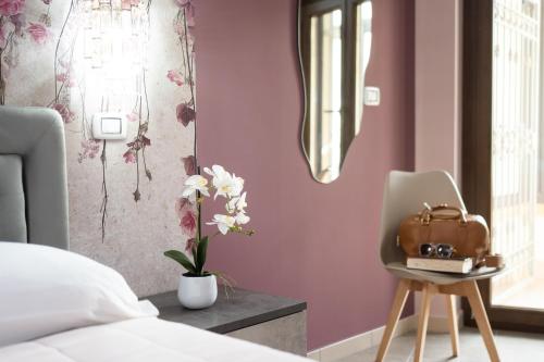 a bedroom with a bed and a chair and flowers at B&B Golden House & spa in Rose