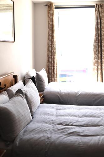 a hotel room with two beds and a window at Ashes Seafood Restaurant Accommodation in Dingle
