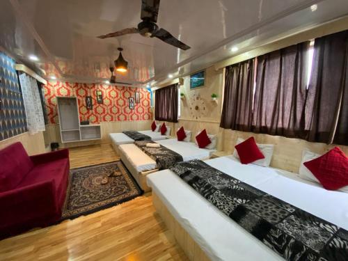 a hotel room with four beds and a couch at Hotel Young Mamta in Srinagar