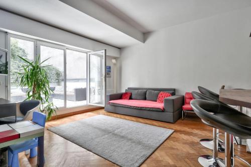 un salon avec un canapé et une table dans l'établissement Family apartment with garden, à Paris