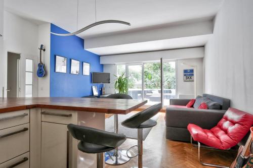 une cuisine avec une table, des chaises et un canapé dans l'établissement Family apartment with garden, à Paris