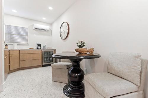 a kitchen with a table and a chair and a clock at Pool Beachfront Studio in Fort Lauderdale