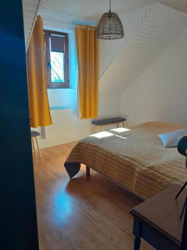 - une chambre avec un lit et une fenêtre avec des rideaux jaunes dans l'établissement Gite Au Bout du Monde, à Confolent-Port-Dieu