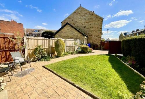 a small garden with a lawn in front of a house at Cosy Home In Sheffield in Handsworth