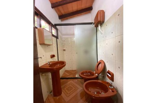 a bathroom with two toilets and a sink at Los Cantares in Piribebuy