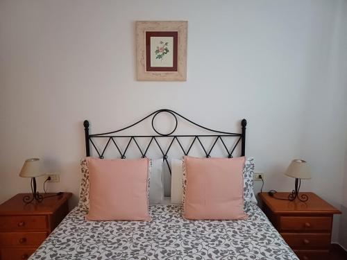 a bedroom with a black and white bed with pink pillows at Vv - Casa Clary -Finca Medina in Alojera