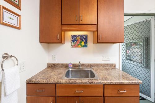a kitchen with a sink and wooden cabinets at Kona Islander Inn#309 in Kailua-Kona