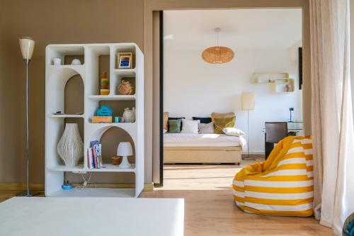 - un salon avec un lit et une étagère blanche dans l'établissement magnifique appartement terrasse - quartier presidents - 4 personnes, à Les Sables-dʼOlonne