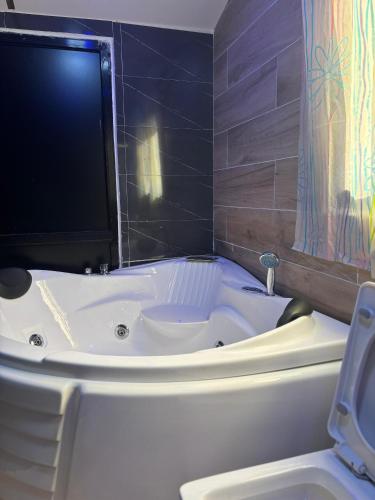 a bath tub with a television on top of it at Studio avec Jacuzzi Aeroport AIBD in Déni Diarke