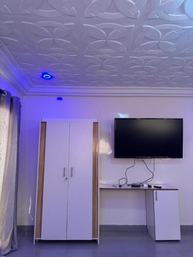 a room with a flat screen tv on a ceiling at Studio avec Jacuzzi Aeroport AIBD in Déni Diarke