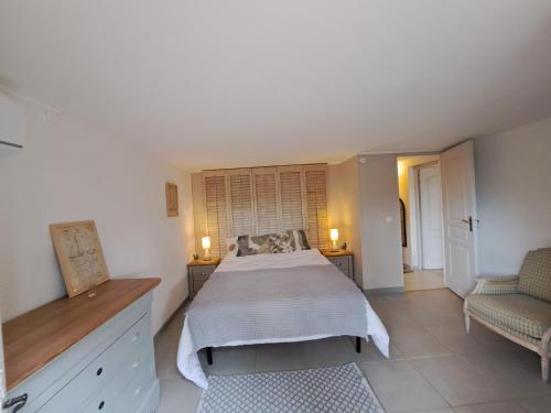 a bedroom with a bed and two chairs at Clos Helene in Hyères