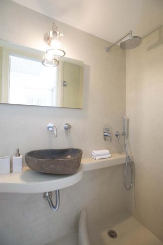 a bathroom with a stone sink and a mirror at PyleanBlue villas in Pylos