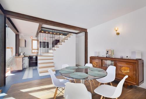 ランブイエにあるL'Arboré, maison d'architecte avec hammamのテーブルと白い椅子のあるダイニングルーム