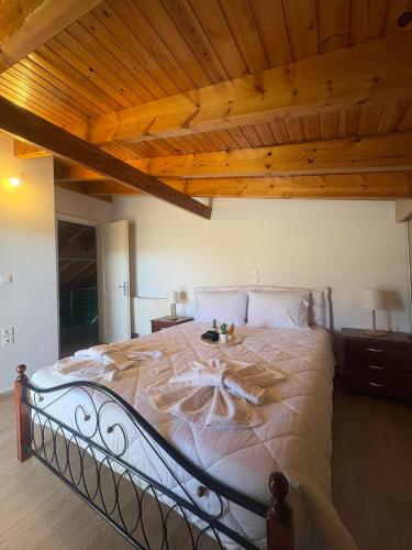 a large bed in a bedroom with a wooden ceiling at Alex house in Kouramaditika