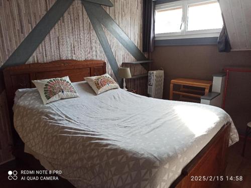 une chambre avec un grand lit avec deux oreillers dans l'établissement PETIT APPARTEMENT 30M2, 3 lits, de 1 à 4 pers, à Neuilly