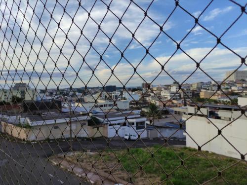 a view of a harbor through a chain link fence at Apartamento amplo ao lado da Avenida da Moda in Passos