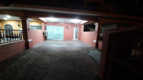 Glory Homestay Ipoh في ايبوه: غرفة فارغة بجدران وردية وباب