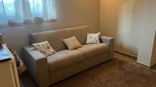 a couch in a living room with pillows on it at Agli Chalet Bosco in Domodossola