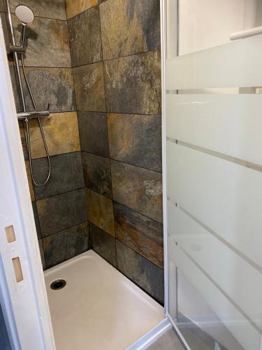 une salle de bain avec une douche avec une porte vitrée dans l'établissement Studio pour 2 personnes - Cossi, à Saintes-Maries-de-la-Mer