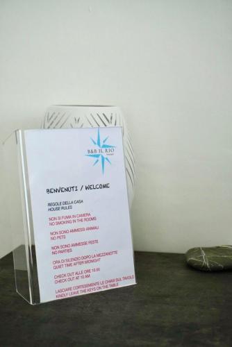 a sign sitting on a table next to a wall at B&B il Rio in Anacapri
