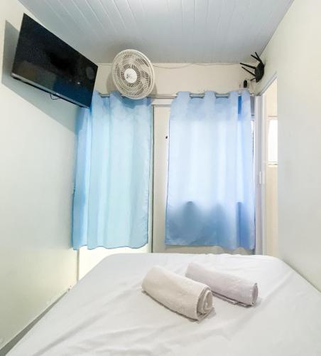 a bed with two pillows in front of a window at Pousada Mirante do César in Bombinhas