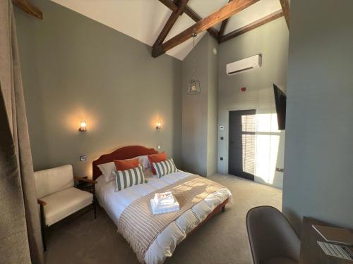 a bedroom with a bed and a chair in it at Akroyd House - The Wainhouse Room in Halifax