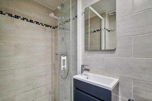 une salle de bain avec un lavabo et une douche en verre dans l'établissement Le Petit Cernay - Studio - 5 mins Caves Champagne, à Reims