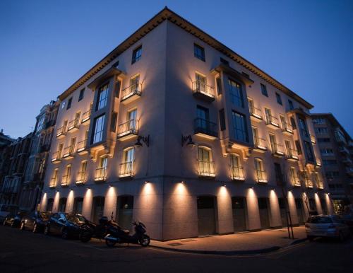 a large white building with motorcycles parked in front of it at Nexus Valladolid Suites & Hotel in Valladolid