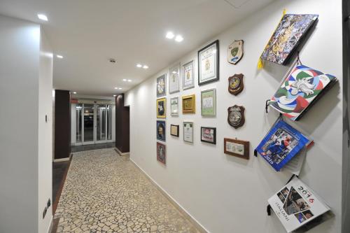 a hallway with a bunch of pictures on a wall at Hotel Testani Frosinone in Frosinone