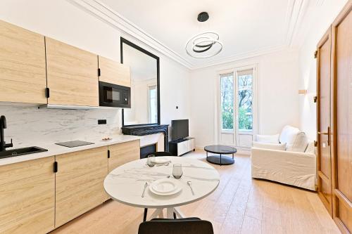 Il comprend une cuisine et un salon avec une table. dans l'établissement Spacieux 3 chambres avec balcon, à Colombes