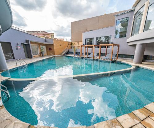 einem Pool mit blauem Wasser vor einem Gebäude in der Unterkunft The Curve by the Park Nairobi by TSG in Nairobi