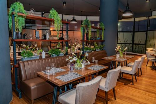 ein Restaurant mit Tischen, Stühlen und Pflanzen in der Unterkunft The Curve by the Park Nairobi by TSG in Nairobi