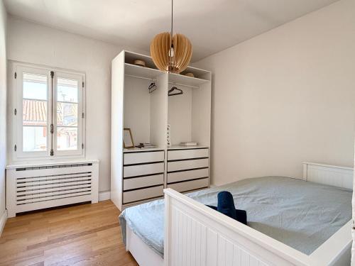 une chambre avec un lit, une commode et un miroir dans l'établissement Essence des Carmes - T3 en hyper centre et climatisé, à Toulouse