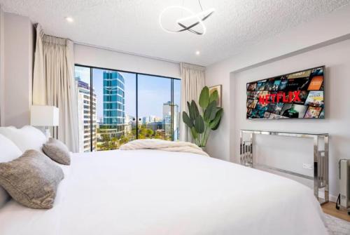 une chambre avec un lit blanc et une grande fenêtre dans l'établissement OceanFront Larcomar Apartments, à Lima