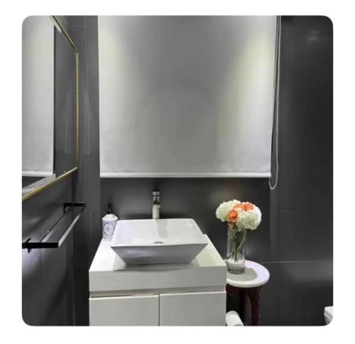 a bathroom with a sink and a vase of flowers at HW Pool Studio in Cidra