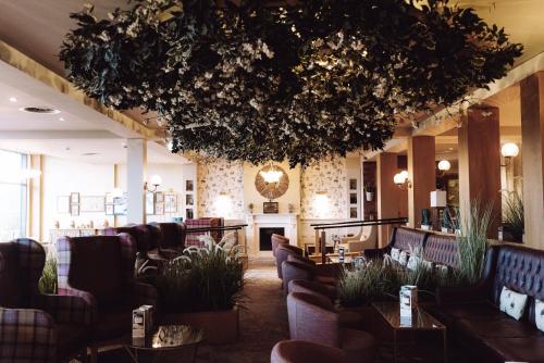 a lobby with couches and tables and a fireplace at Warner Hotels - Studley Castle in Studley