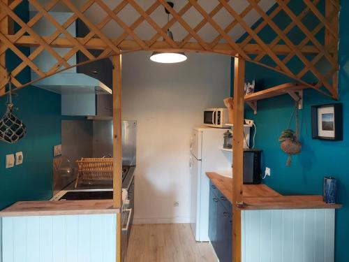 Il comprend une cuisine avec un réfrigérateur blanc et un plafond en bois. dans l'établissement Ti Laouen, à Plouézec