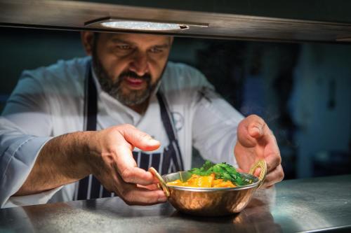 a man is holding a bowl of food at Warner Hotels - Studley Castle in Studley