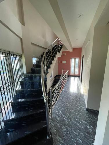 a spiral staircase in a building with red walls at Deqorum villas in Kumbakonam