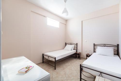 two beds in a room with white walls at House in Eleusis (Elefsina) a city close to Athens in Elefsina