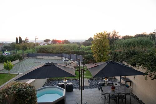 un patio con 2 ombrelloni e una piscina di La casa di Gabry Superior ad Albano Laziale