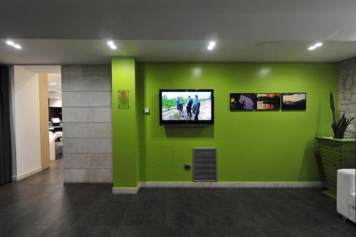 a green wall with a flat screen tv on it at Hotel Testani Frosinone in Frosinone