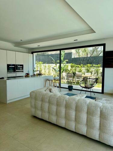 un salon avec un canapé blanc dans une cuisine dans l'établissement Villa Clara chambre double, à La Ciotat